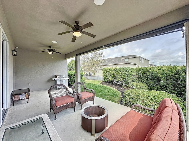 view of patio with an outdoor living space with a fire pit, ceiling fan, and fence