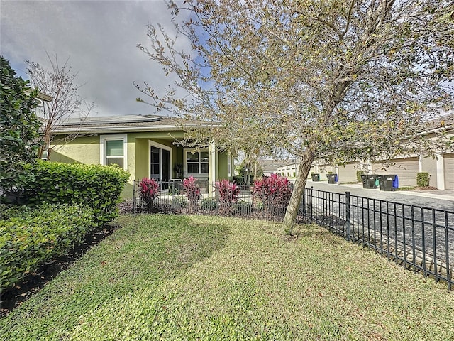 view of yard with a fenced front yard, driveway, and a porch