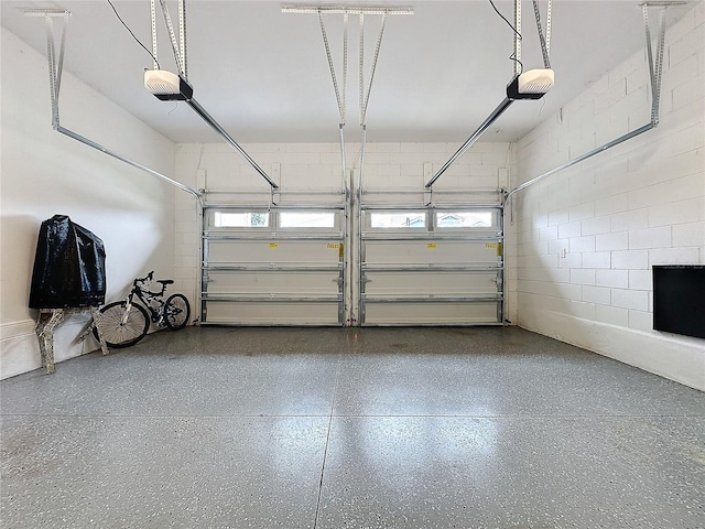 garage with concrete block wall and a garage door opener