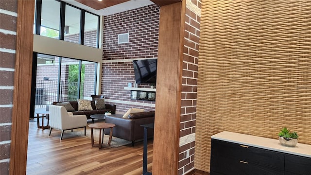 living room featuring a towering ceiling and wood finished floors