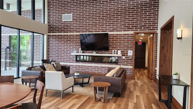 living room with a towering ceiling and light wood-style flooring