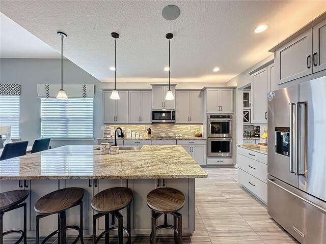 16150 Parkwyn St, Winter Garden, FL 34787 - kitchen with backsplash, a breakfast bar area, stainless steel appliances, and a sink