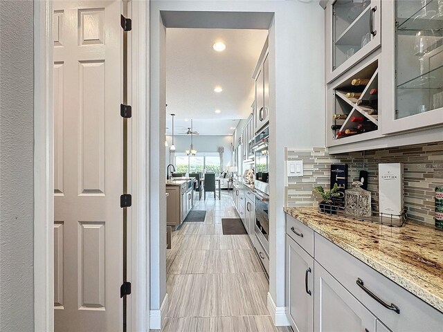 16150 Parkwyn St, Winter Garden, FL 34787 - bar with double oven, tasteful backsplash, a sink, and recessed lighting
