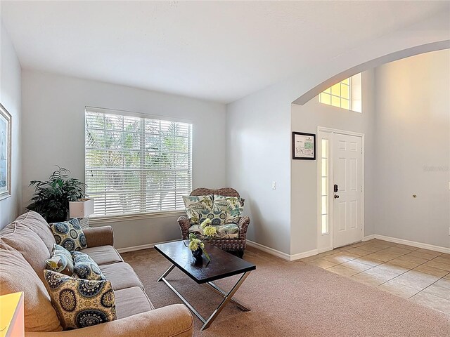 131 Stella Pass, Davenport, FL 33837 - living area featuring arched walkways, plenty of natural light, baseboards, and light tile patterned floors