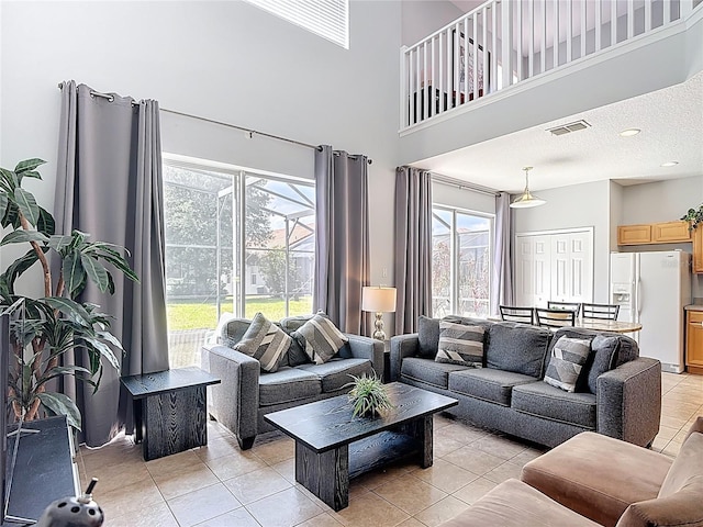 131 Stella Pass, Davenport, FL 33837 - living room featuring light tile patterned flooring, a high ceiling, and healthy amount of natural light