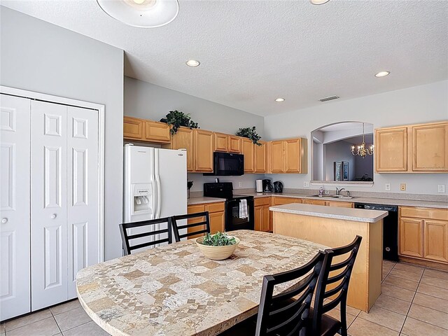 131 Stella Pass, Davenport, FL 33837 - kitchen with black appliances, a center island, a sink, light tile patterned floors, and a chandelier