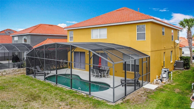 131 Stella Pass, Davenport, FL 33837 - back of house featuring a patio, a tiled roof, cooling unit, and a lawn