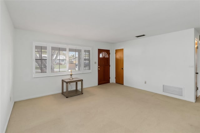 empty room featuring visible vents and light colored carpet