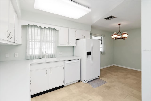 kitchen featuring white appliances, white cabinetry, visible vents, light countertops, and pendant lighting