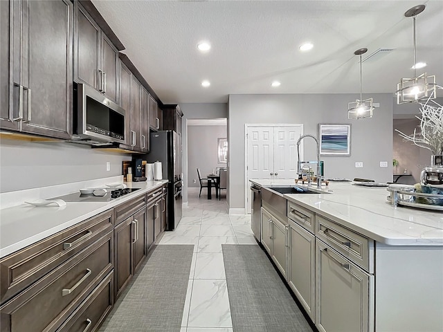 kitchen featuring marble finish floor, stainless steel appliances, recessed lighting, a kitchen island with sink, and a sink