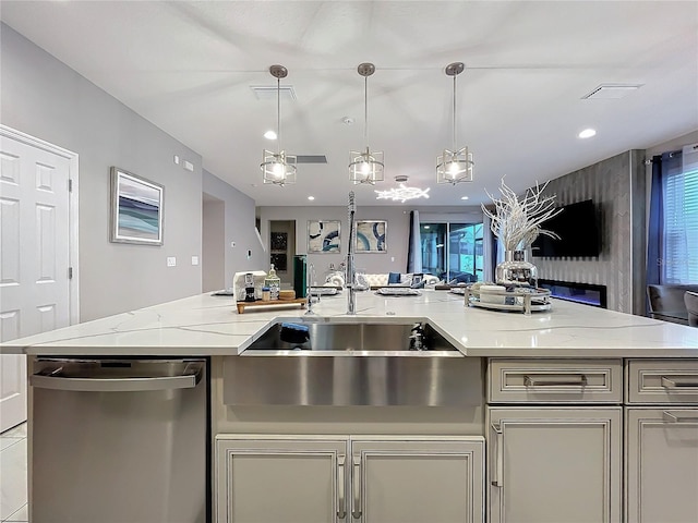 kitchen featuring a sink, light stone countertops, open floor plan, and dishwasher