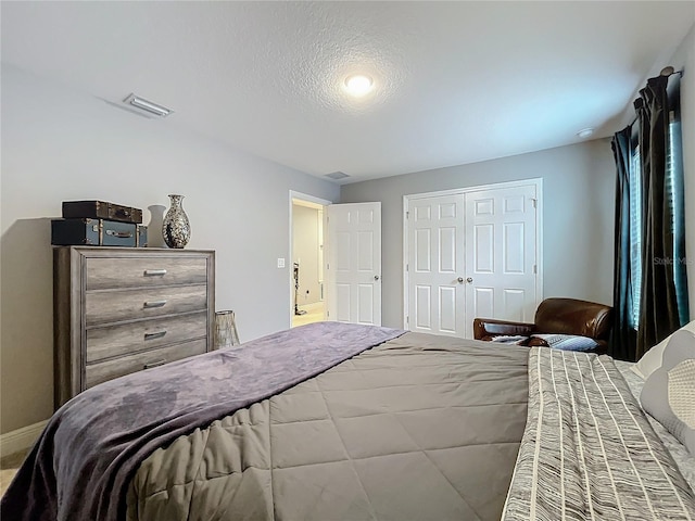 bedroom with a closet, visible vents, and baseboards