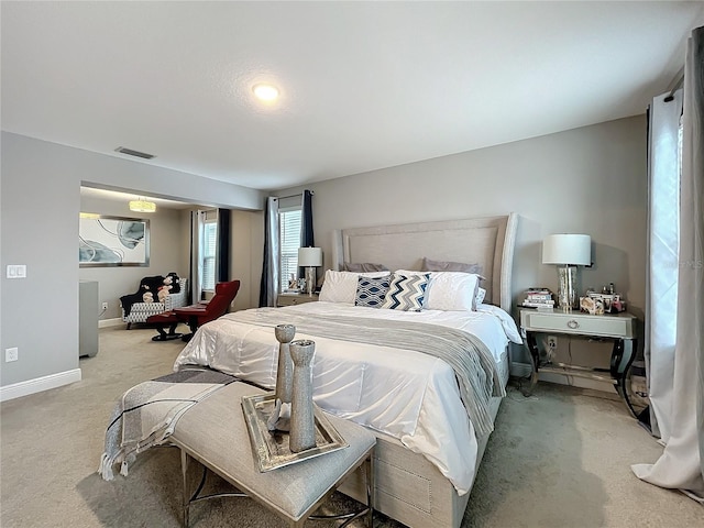 bedroom featuring light carpet, visible vents, and baseboards