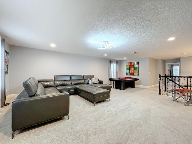 living room featuring recessed lighting, baseboards, a textured ceiling, and light colored carpet