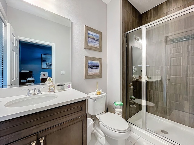 bathroom featuring toilet, a shower stall, and vanity