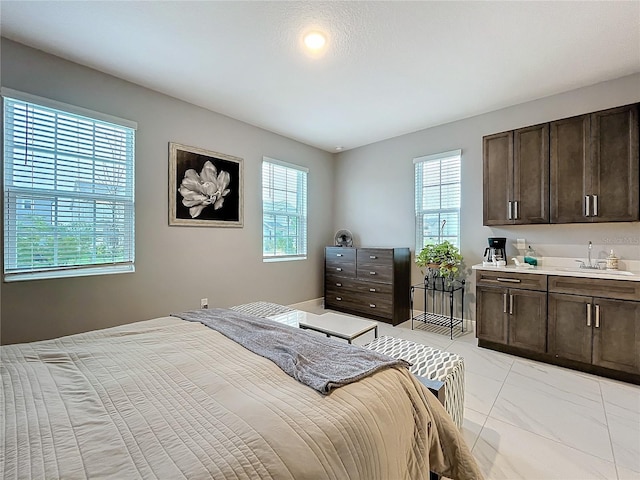 bedroom featuring marble finish floor, multiple windows, and a sink