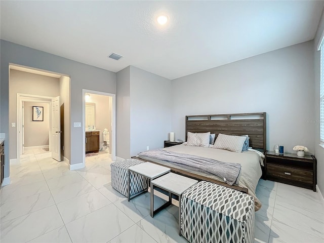 bedroom featuring ensuite bath, marble finish floor, baseboards, and visible vents