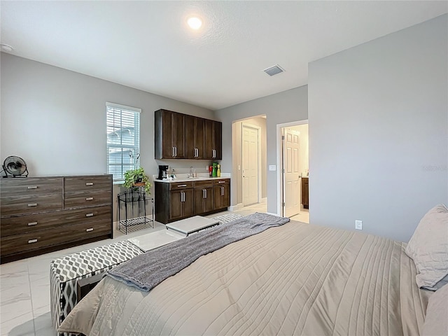 bedroom featuring marble finish floor, visible vents, and a sink