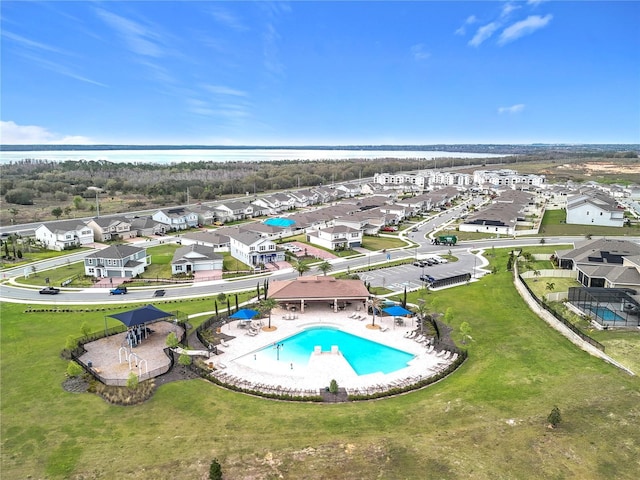 view of swimming pool featuring a water view, a patio area, and a residential view