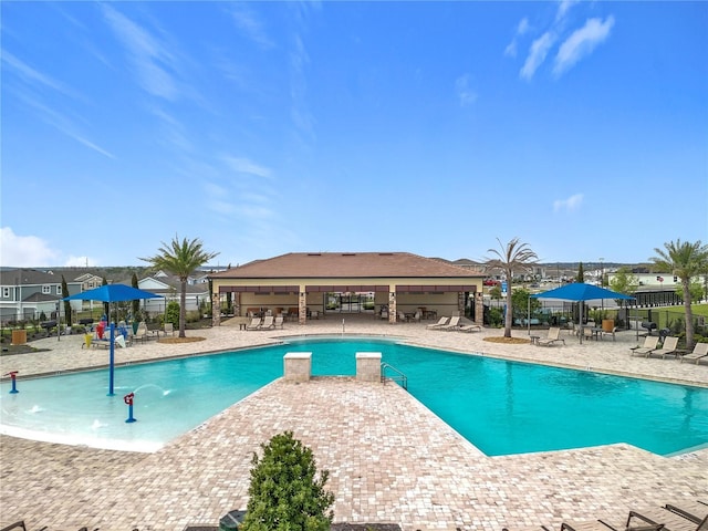 community pool with a patio area and fence