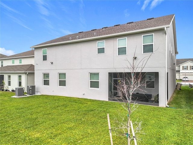 rear view of house with stucco siding, a lawn, and central air condition unit