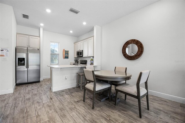 8012 Lost Shaker Ln, Kissimmee, FL 34747 - dining area featuring baseboards, visible vents, and light wood finished floors