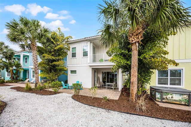 8012 Lost Shaker Ln, Kissimmee, FL 34747 - view of front facade featuring a patio area, stucco siding, board and batten siding, and a balcony