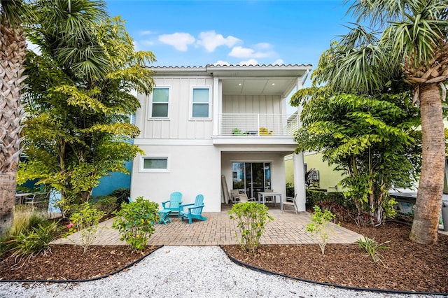 8012 Lost Shaker Ln, Kissimmee, FL 34747 - back of house featuring stucco siding, board and batten siding, a balcony, and a patio
