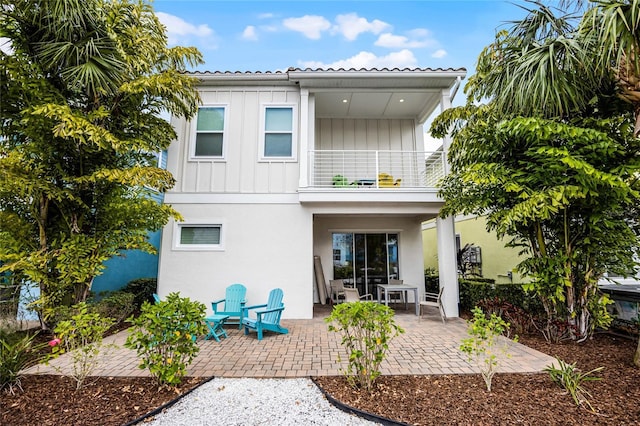 8012 Lost Shaker Ln, Kissimmee, FL 34747 - back of house with stucco siding, a patio, a balcony, and board and batten siding