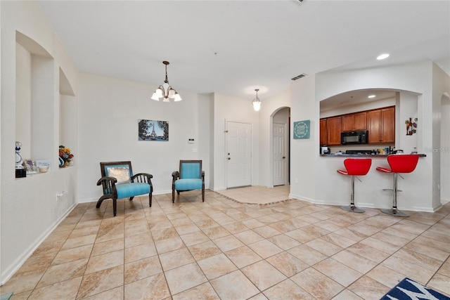 living area featuring light tile patterned floors, arched walkways, recessed lighting, visible vents, and baseboards