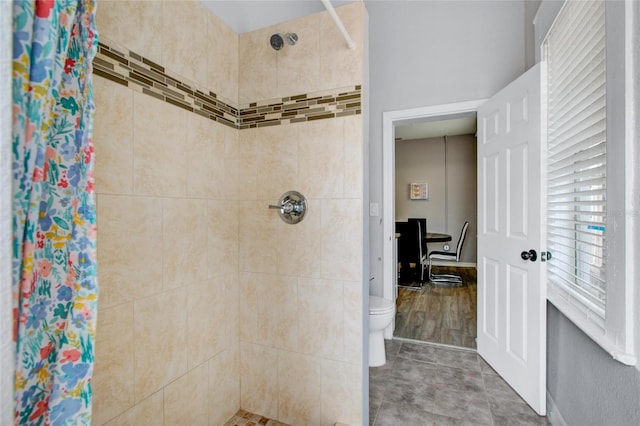 bathroom with a stall shower, toilet, and tile patterned floors