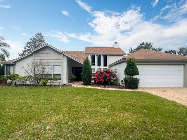 view of front of house with a chimney, a front lawn, decorative driveway, and stucco siding