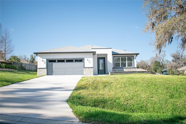 prairie-style house featuring driveway, stone siding, stucco siding, an attached garage, and a front yard