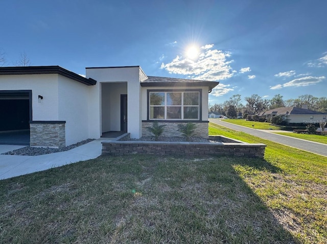 view of front of house featuring stucco siding and a front yard