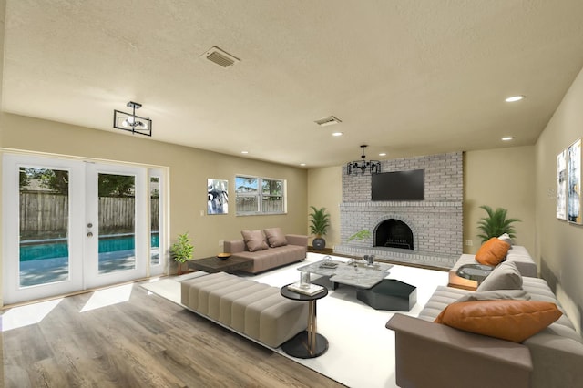 628 Eastwood Ct, Altamonte Springs, FL 32714 - living area with french doors, a fireplace, visible vents, a textured ceiling, and wood finished floors