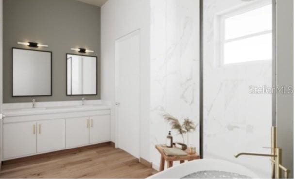 full bathroom with wood finished floors, a freestanding bath, and double vanity