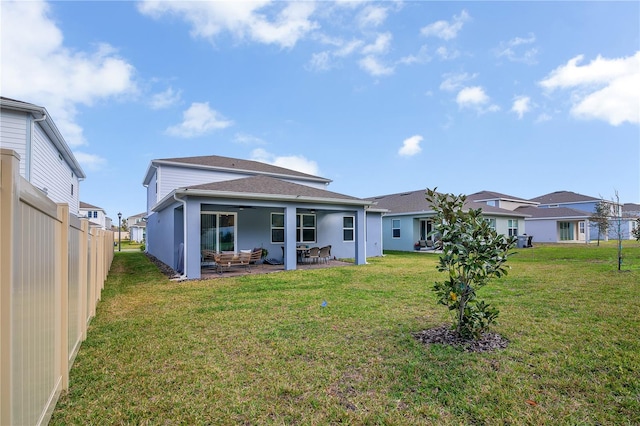 rear view of house with a patio, a lawn, fence, and a residential view