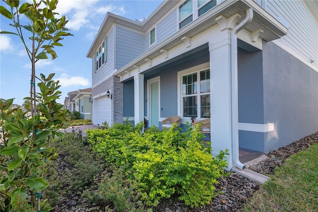 view of side of home with a garage and stucco siding