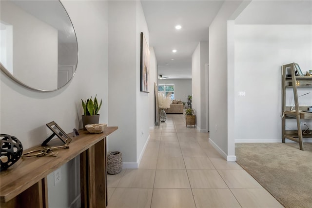 hall with light tile patterned floors, recessed lighting, baseboards, and light colored carpet