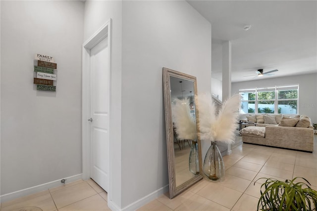 corridor with light tile patterned floors and baseboards