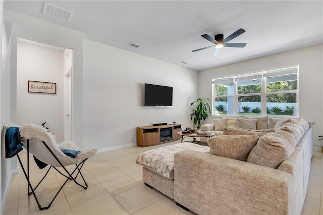 living room featuring light tile patterned floors, ceiling fan, visible vents, and baseboards