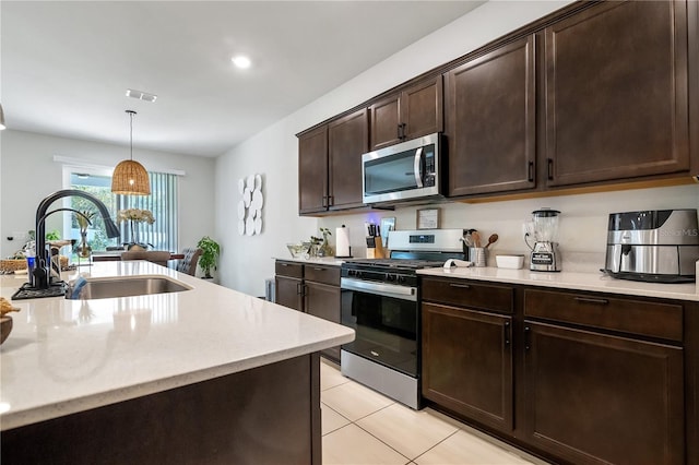 kitchen featuring a sink, visible vents, light countertops, appliances with stainless steel finishes, and pendant lighting