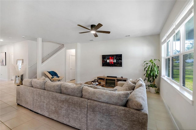 living room with baseboards, visible vents, stairway, a fireplace, and light tile patterned flooring