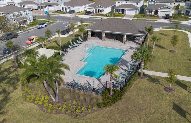 community pool featuring fence and a residential view