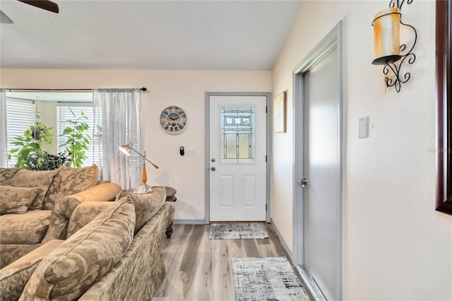 interior space featuring a textured ceiling, light wood-type flooring, and baseboards