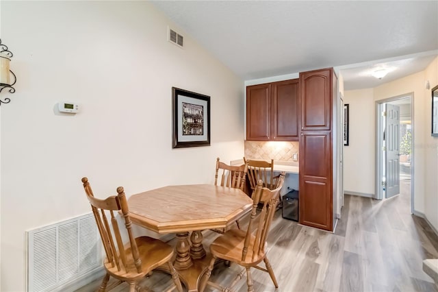 dining area featuring baseboards, visible vents, and light wood finished floors