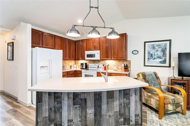 kitchen with light wood-style flooring, white appliances, vaulted ceiling, light countertops, and backsplash