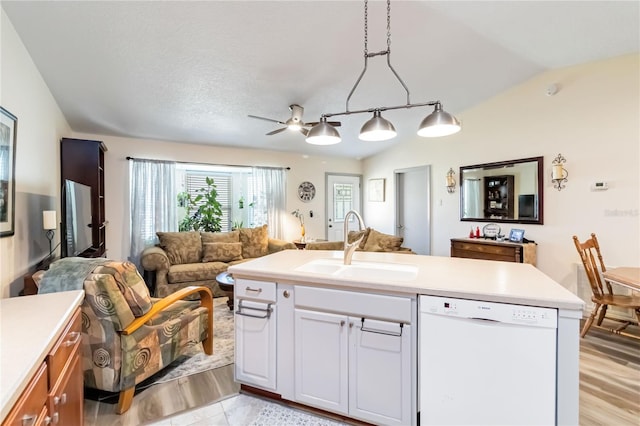 kitchen with lofted ceiling, white dishwasher, a sink, open floor plan, and light countertops