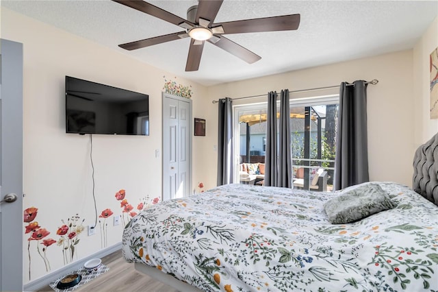 bedroom featuring a textured ceiling, ceiling fan, a closet, and wood finished floors