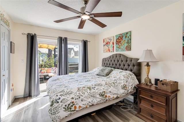 bedroom with access to exterior, light wood-style floors, a ceiling fan, a textured ceiling, and baseboards